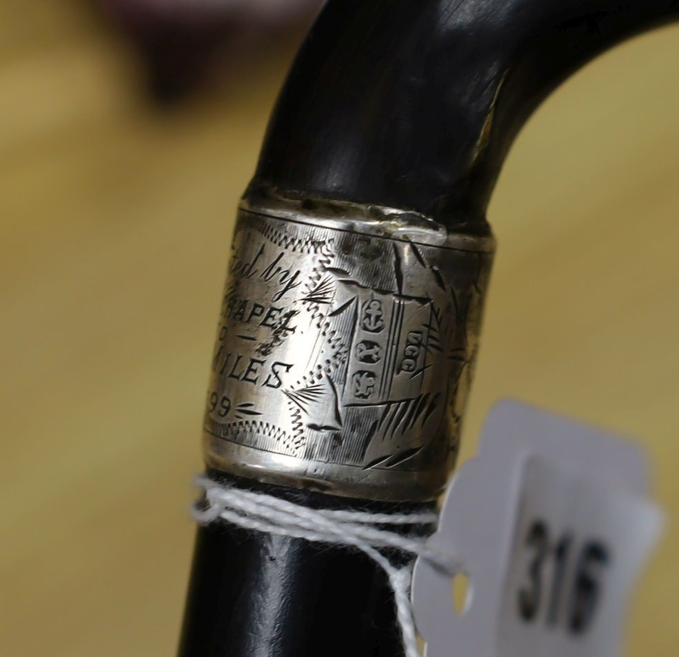 A silver mounted cane with a phallic shaped handle, presented by N.D.T. Chapel to W.H. Miles, 1899. 82cm high